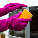 cleaning a microwave oven with gloves