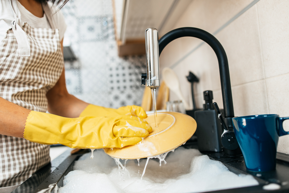 cleaning dishes with dishwashing gloves