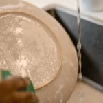 scrubbing dishes with hands