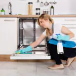 a lady cleaning a dishwasher