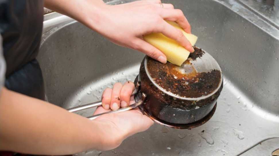 women's hands to polish burned pot