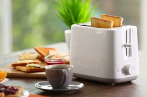 a bread toaster with slices of bread and a cup of tea