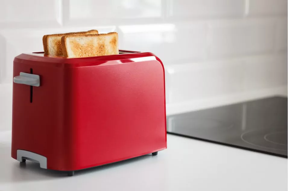 a red colored bread toaster with 2 bread slices