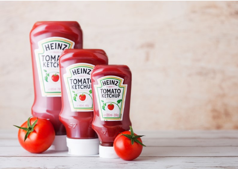 bottles of tomato ketchup along with tomatoes