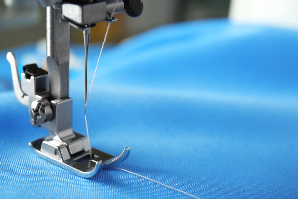 sewing a blue colored fabric cloth