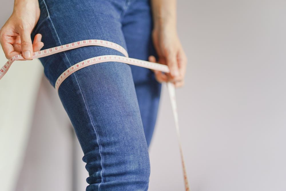 a woman measuring her inseam length