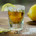 a glass of tequila with lemon and salt