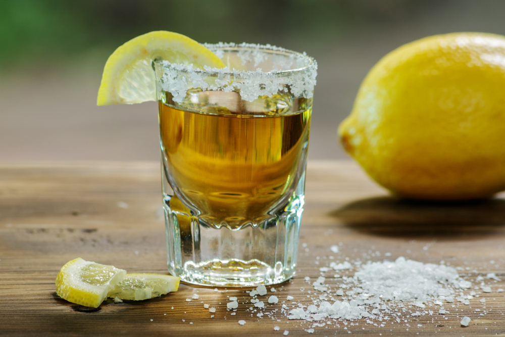 a glass of tequila with lemon and salt
