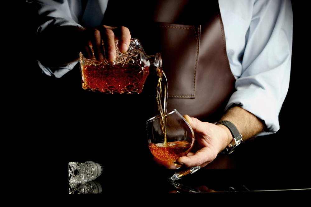 a man pouring brandy in glass
