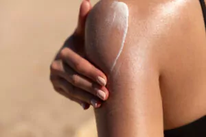 a girl applying sunscreen on her body