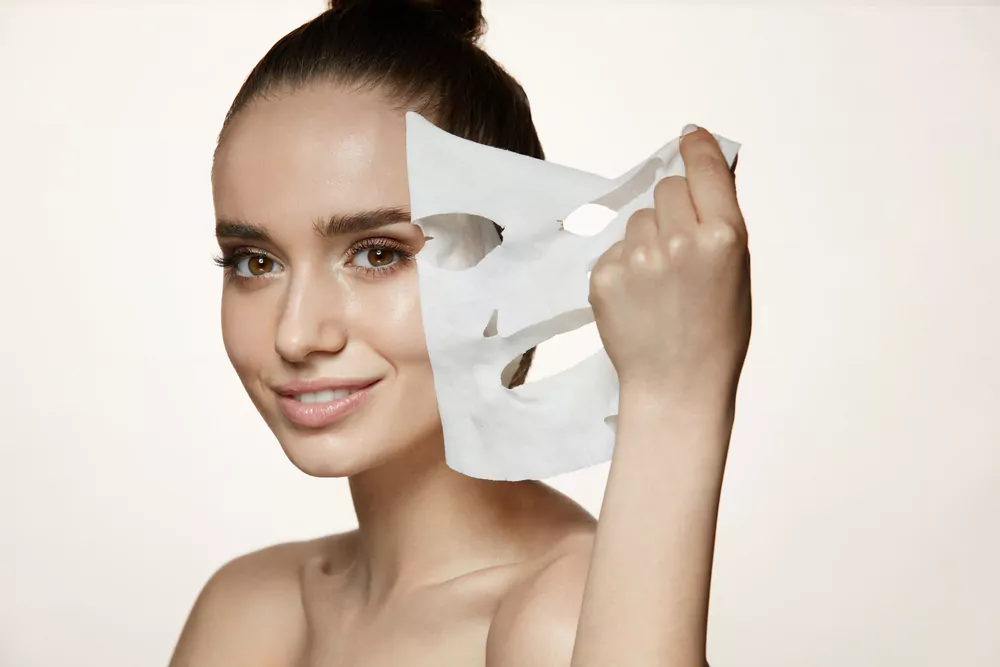 a lady removing the face mask sheet