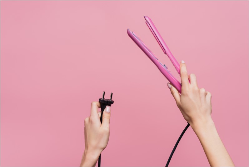 a woman plugging In philips hair straightener