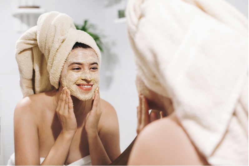 a young girl exfoliating her face with a scrub
