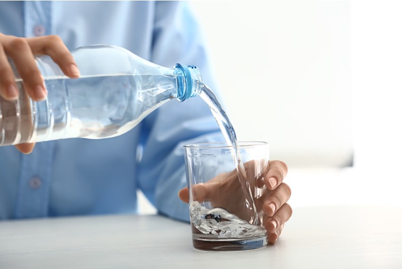 a woman pouring water in glass