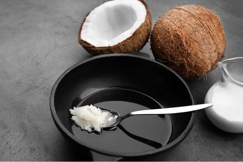 spoon with coconut oil on frying pan