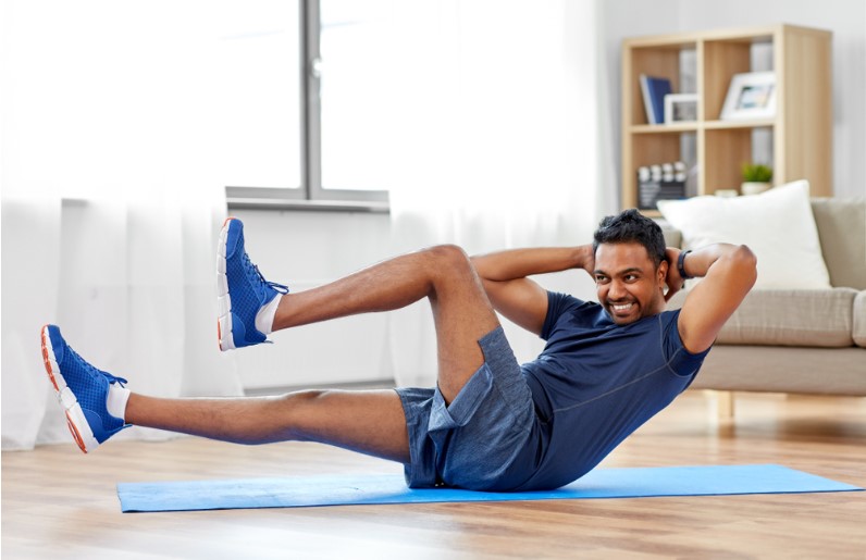 indian man making abdominal exercises at home