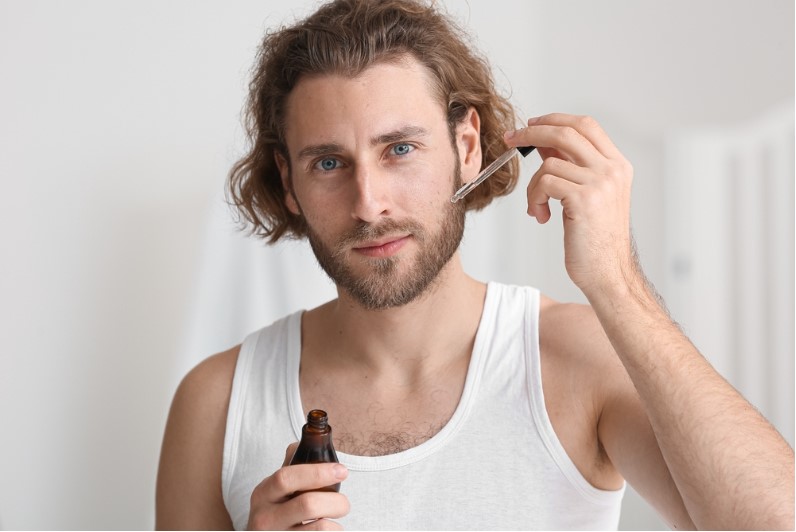 young man using serum for beard