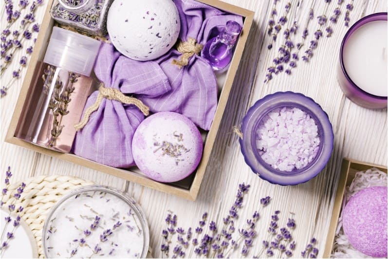 lavender scented spray and sachets on wooden table