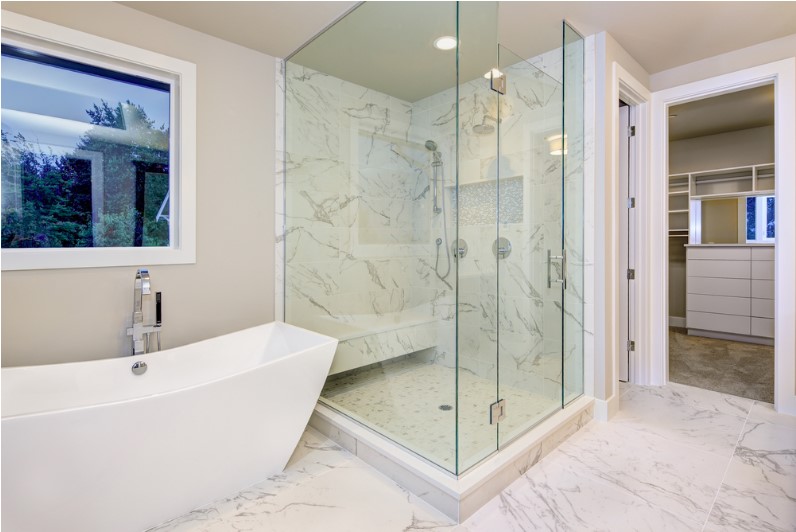 sleek bathroom features freestanding bathtub atop marble floor placed in front of glass shower accented with rain shower head
