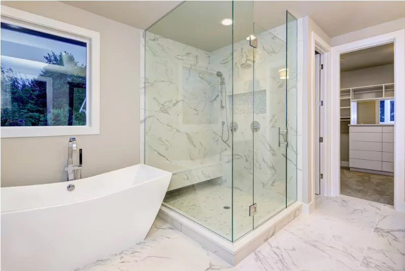 sleek bathroom features freestanding bathtub atop marble floor placed in front of glass shower accented with rain shower head