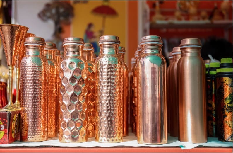 different copper bottles on display in a store