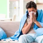 sick young man suffering from flu at home