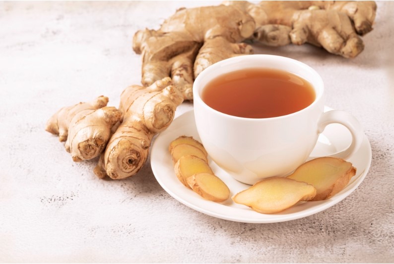 cup of hot ginger tea with ginger root and slices