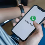 man holding iphone with whatsapp logo on cellphone screen