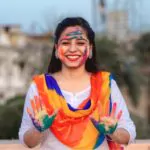 woman celebrating holi with powder colours or gulal