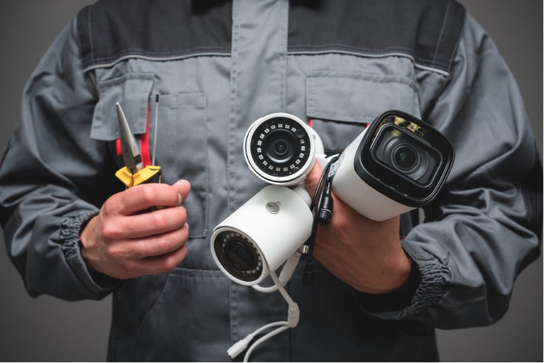 a technician holding cctv cameras from 3 different brands