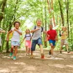a group of children with backpacks makes a race in nature in the summer camp