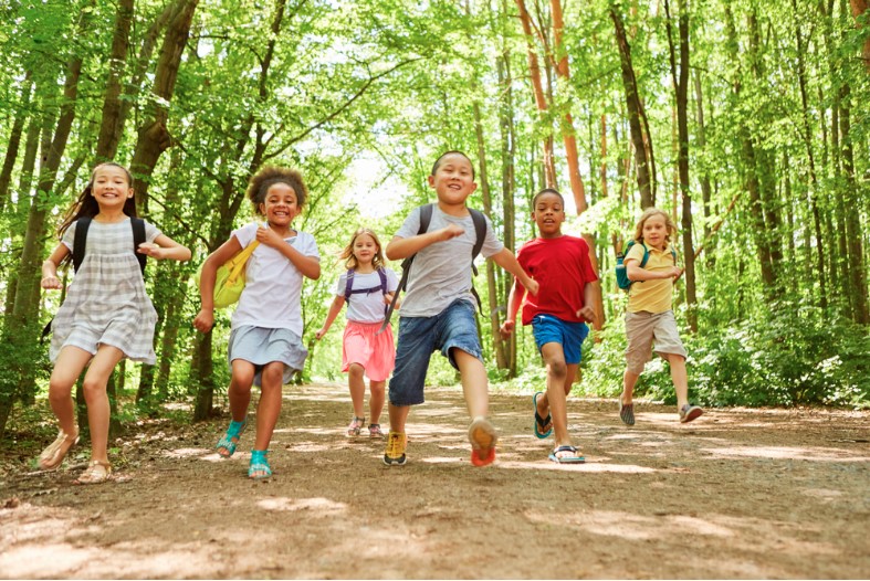 a group of children with backpacks makes a race in nature in the summer camp