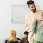 happy arabian man embracing muslim wife near blurred multiethnic family
