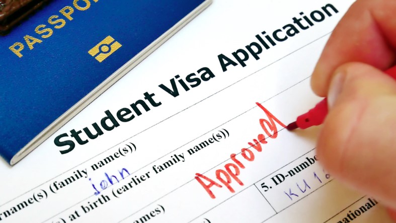 pen voting approved in the checkbox in blank student visa application form with passport and pen