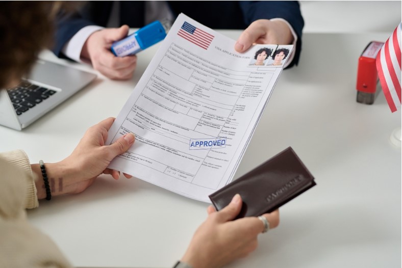 close-up of a woman getting a us visa in the immigration office and holding approved forms