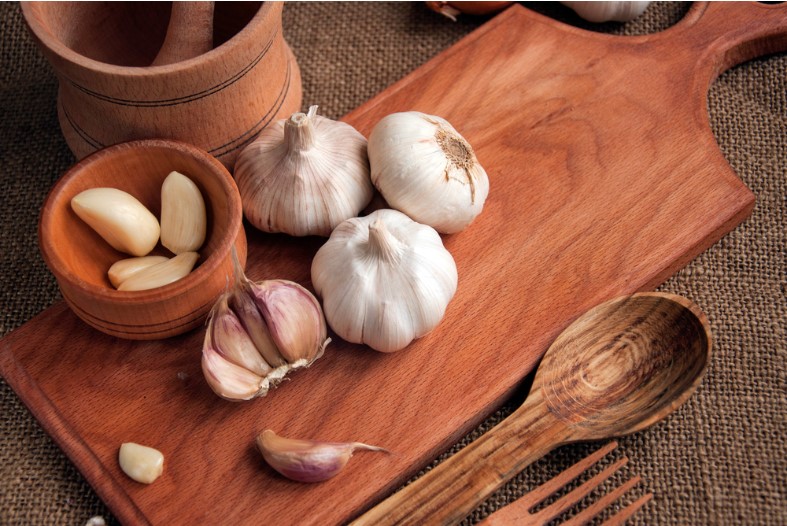 garlic cloves with garlic on wooden tray and spoon