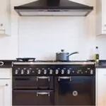 painted wood modern kitchen with black enamel range cooker and chimney hood