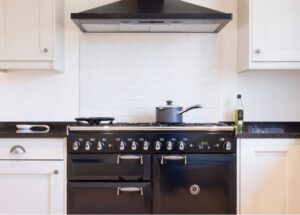painted wood modern kitchen with black enamel range cooker and chimney hood