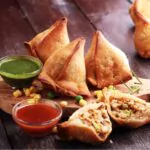 veg indian samosa on a table with sweet and spicy chutney