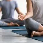 close-up young people wearing sportswear practicing yoga at group lesson