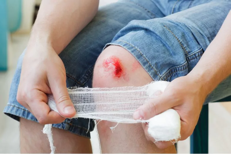 man heals the wound on his knee at home