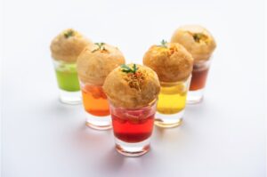 pani puri shot or golgappa shots different flavors of water served in small glasses with stuffed puri