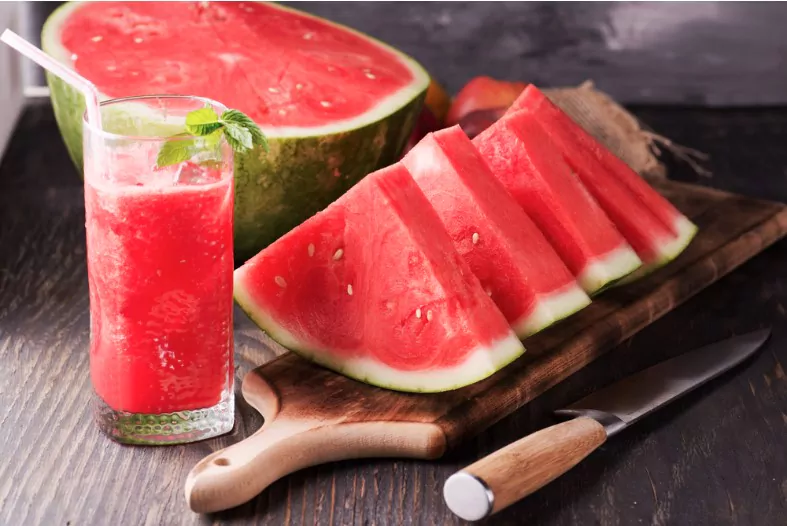 fresh watermelon juice with ice in a glass slices of watermelon on the table