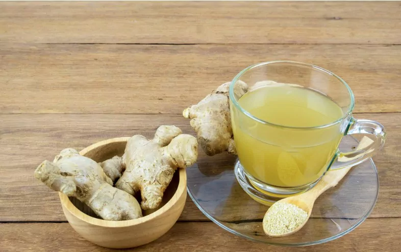 ginger and ginger water in a cup on a wooden table at home