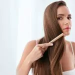 hair care woman combing beautiful long hair with a wooden brush