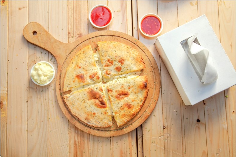 aerial top shot of stuffed cheese paratha with dip