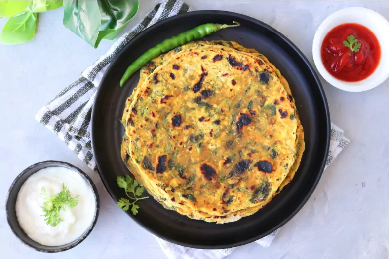 methi paratha or methi thepla is a indian breakfast dish served with curd and ketchup