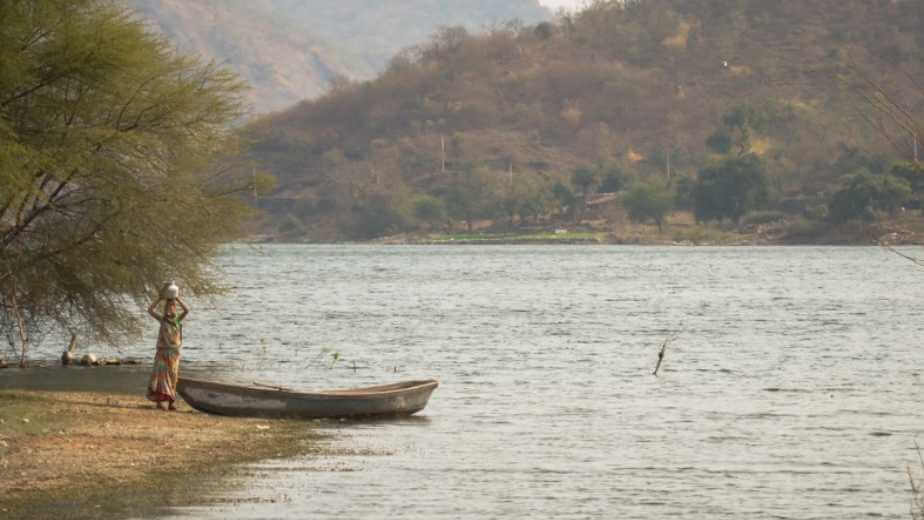 a tribal woman filling water from jaisamand lake in udaipur