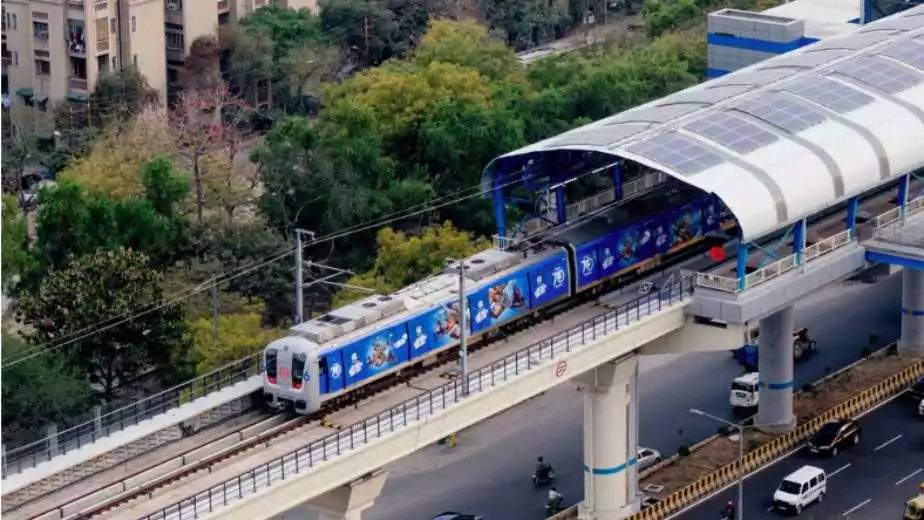 aerial shot of metro train arriving at an elevated metro station in delhi