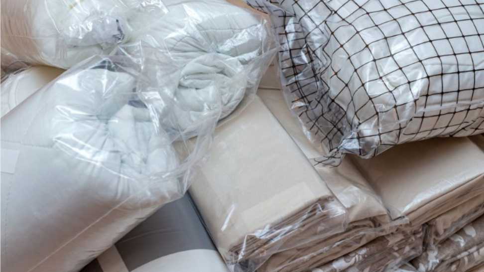 white and beige packed pile of the linen bedclothes blanket with pillow and bedding sheets
